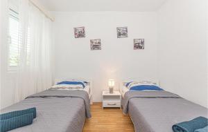 ein Schlafzimmer mit 2 Betten und einem Tisch mit einer Lampe in der Unterkunft 5 Bedroom Lovely Home In Cista Velika in Velika Čista