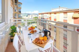a balcony with a table with bread and oranges on it at CITY CENTER AND NEXT TO THE BEACH 3 BEDROOMs in Málaga