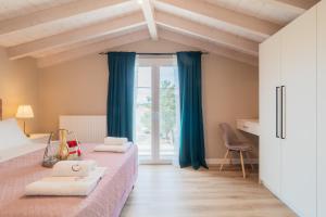 a bedroom with two beds and a window at Melena Premium Suites in Roda