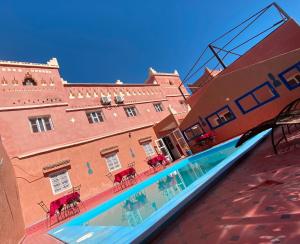 a swimming pool in front of a building at La Baraka Auberge in Aït Benhaddou