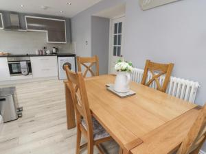 a kitchen with a wooden table with a vase of flowers on it at 4 Tyne View in Hexham