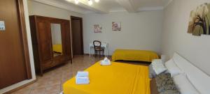 Portacomaro的住宿－Casa Graziella - la casetta，一间设有黄色床和一张桌子的房间