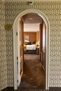 Un arco que conduce a un dormitorio con cama en Hotel & Restaurant Infinity, en Lichtmis