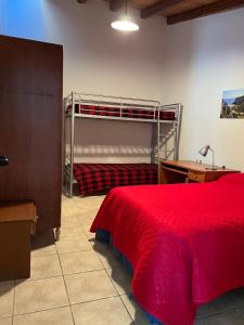 1 dormitorio con litera y colcha roja en Vicol8 Casa Vacanze, en Dorgali