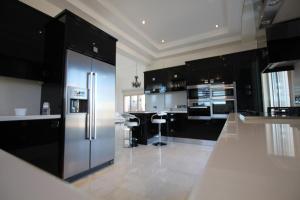 uma cozinha com um frigorífico de aço inoxidável e armários pretos em Eagles Cliff Villa em Kathikas