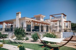 a large house with a hammock in the yard at Eagles Cliff Villa in Kathikas