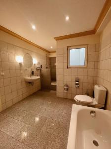 a bathroom with a tub and a toilet and a sink at Apartment Josephine in Lübeck