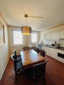 a kitchen with a wooden dining table and chairs at Apartment Josephine in Lübeck