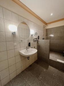 a bathroom with a sink and a shower with a mirror at Apartment Josephine in Lübeck