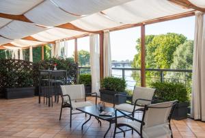 a patio with tables and chairs and windows at Best Quality Hotel La Darsena in Moncalieri