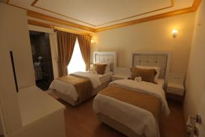 pokój hotelowy z 2 łóżkami i oknem w obiekcie GARDEN OTEL AMASYA w mieście Amasya