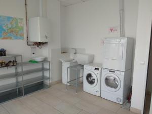 uma lavandaria com uma máquina de lavar roupa e uma máquina de lavar roupa em Check In León em Leão