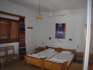 een slaapkamer met 2 bedden en een stoel. bij Stelios in Agia Galini