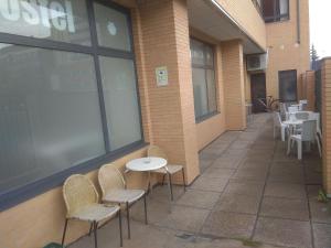 eine Terrasse mit Stühlen und Tischen sowie ein Gebäude in der Unterkunft Check In León in León