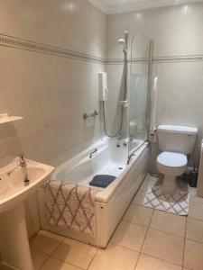 een badkamer met een bad, een toilet en een wastafel bij Sir Andrew Murray House in Strathyre