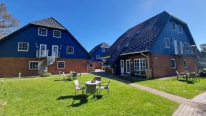 a group of houses with a table and chairs in the grass at Captain Pahlen Ferienanlage in Zingst