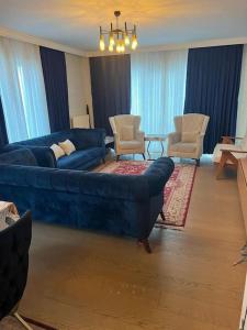 een woonkamer met een blauwe bank en stoelen bij The VIP Guest - Luxury Home in Deniz in Istanbul