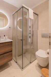 a bathroom with a shower and a toilet and a sink at Melena Premium Suites in Roda