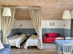 um quarto com 2 camas e um sofá vermelho em Strandbergs Stugor em Mariehamn