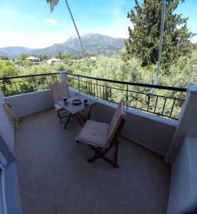 balkon z 2 krzesłami i stołem na balkonie w obiekcie Olivo Nydri w mieście Nydri