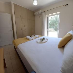 a bedroom with a large white bed with a sink at Olivo Nydri in Nydri