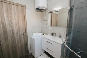 a bathroom with a toilet and a sink and a mirror at Royal Blue House 2 in Kaštela +10 photos
