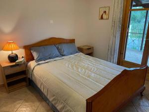 1 dormitorio con cama, lámpara y ventana en greengold Holiday Home - Ancient Pisa en Olympia
