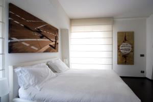 Un dormitorio con una cama blanca y una pintura en la pared en Marvel House - By My Home In Como en Como