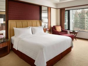 a hotel room with a large bed and a chair at Shangri-La Kuala Lumpur in Kuala Lumpur