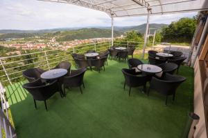 a group of tables and chairs on a balcony with a view at Hotel Dusan si Fiul Resita Sud in Reşiţa