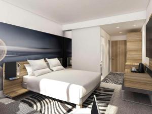 a bedroom with a white bed and a blue wall at Novotel London Canary Wharf in London