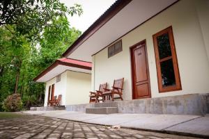 a house with two chairs sitting outside of it at Hotel & Villa Bukit Indah Saumlaki by LeGreen 