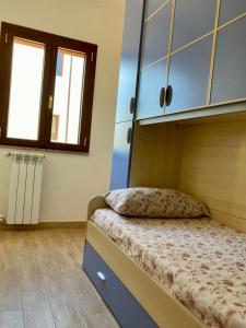 a bedroom with a bed with a cabinet and a window at Smeralda in Olbia