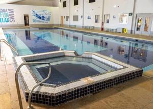 a large swimming pool in a building at Cornish Holiday - 100 Hengar Manor in Bodmin