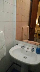 ein Badezimmer mit einem weißen Waschbecken und einem Spiegel in der Unterkunft My Colombo Place in Lissabon