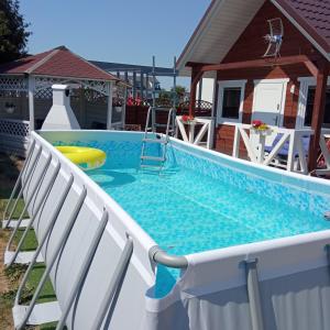 a swimming pool with two chairs and a swimming pool at Domki letniskowe Na Stoku in Władysławowo
