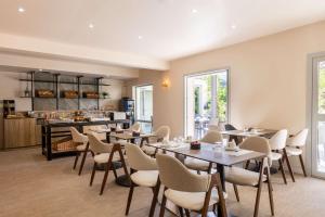 a restaurant with tables and chairs and a kitchen at Best Western Hotel & SPA Coeur De Cassis in Cassis