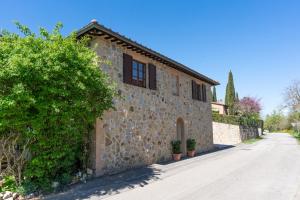 a stone house with a stone wall at Appartamenti le Ginestre in Lupompesi