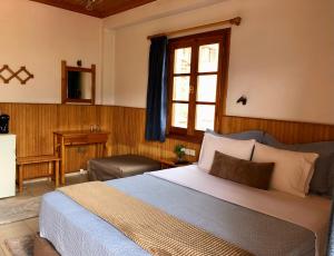 Un dormitorio con una cama grande y una ventana en Apostolos Hotel, en Metsovo