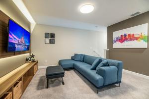 uma sala de estar com um sofá azul e uma televisão de ecrã plano em Magical Disney Vacation Home - 5 bedrooms em Kissimmee