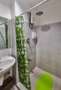 a bathroom with a shower with a green shower curtain at Reese @ Sea Residences Manila in Manila