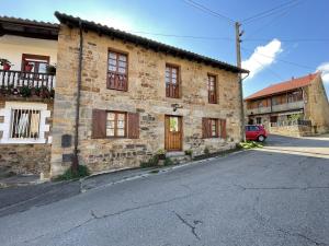 an old stone house on the side of a street at Casa Rustica Con Porche in Bostronizo