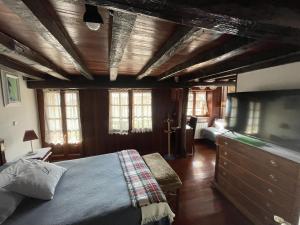 a bedroom with a bed and a dresser and windows at Casa Rustica Con Porche in Bostronizo