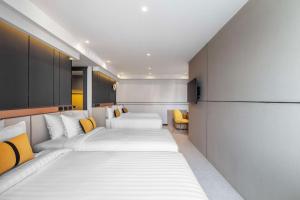 Best Western Ratchada Hotel في بانكوك: غرفة فندقية بسريرين وكراسي صفراء