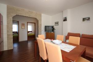 a dining room and living room with a table and chairs at Apartments Rose in Poreč