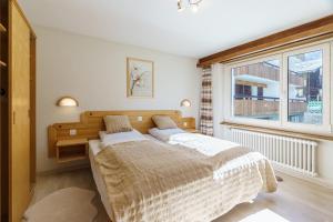 a bedroom with a large bed and a window at Haus Alfa in Saas-Fee