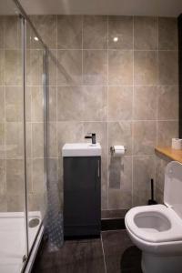 a bathroom with a toilet and a glass shower at Hyper-central Newquay, sleeps 3 in Newquay