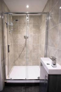 een badkamer met een douche, een wastafel en een bad bij Hyper-central Newquay, sleeps 3 in Newquay