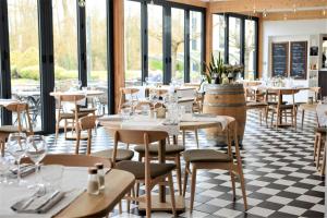 restauracja ze stołami, krzesłami i oknami w obiekcie Domaine de Charmeil w mieście Saint-Quentin-sur-Isère