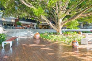 un centro comercial con bancos y un árbol en el centro en Metro Hotel Miranda, en Miranda